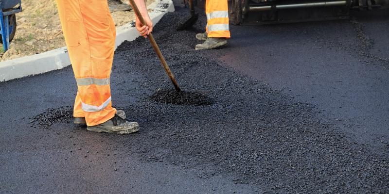 G & M employee repairing asphalt driveway
